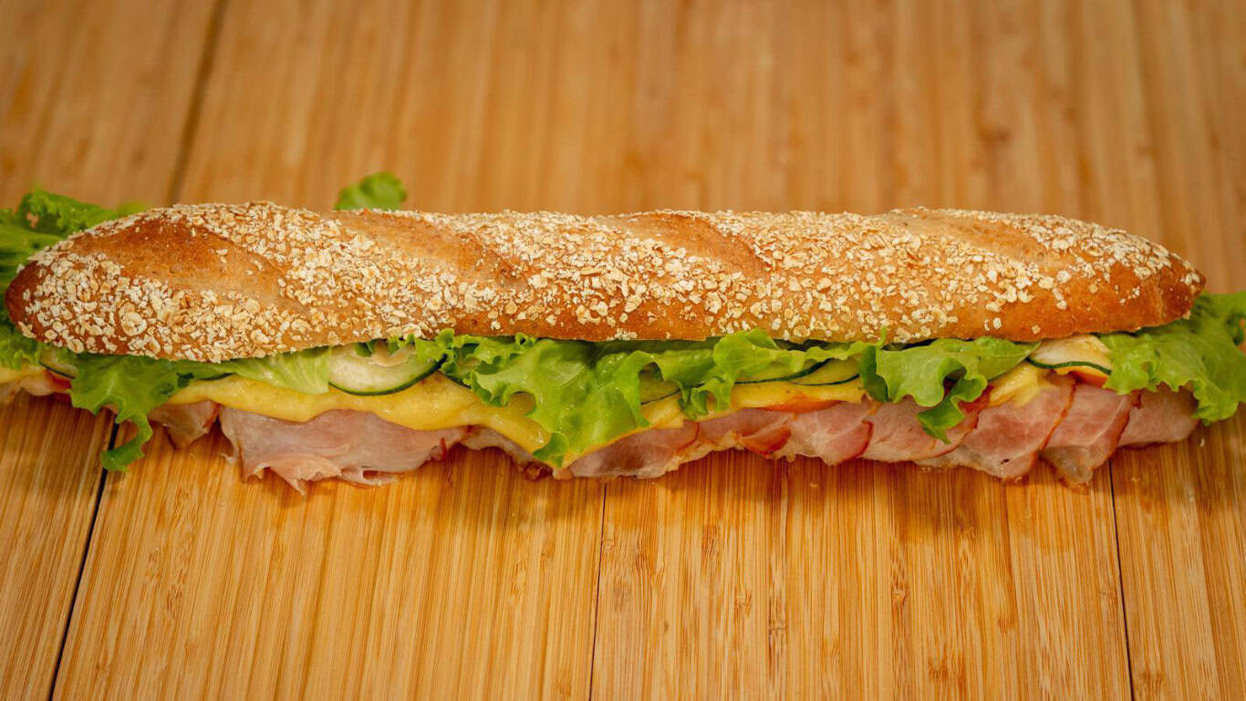 One of the Sandwichery&rsquo;s deli sandwiches, stacked with homemade cold cuts, cheese, fresh lettuce and veggies